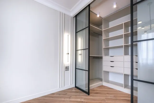 Dressing vitré et parquet dans une chambre rénovée
