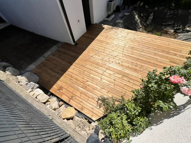 La terrasse en bois terminée devant la porte-fenêtre